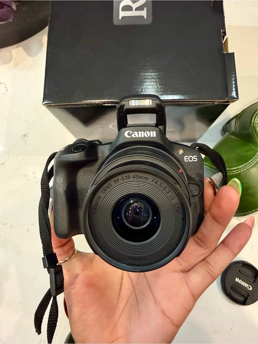Canon EOS R50 Black Mirrorless Camera with Red-Trim Strap and Green Case